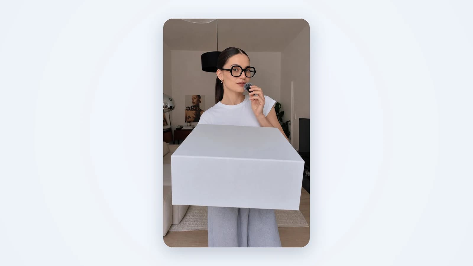 An AI presenter holding a product box in a bright living room, filmed in a vertical phone frame
