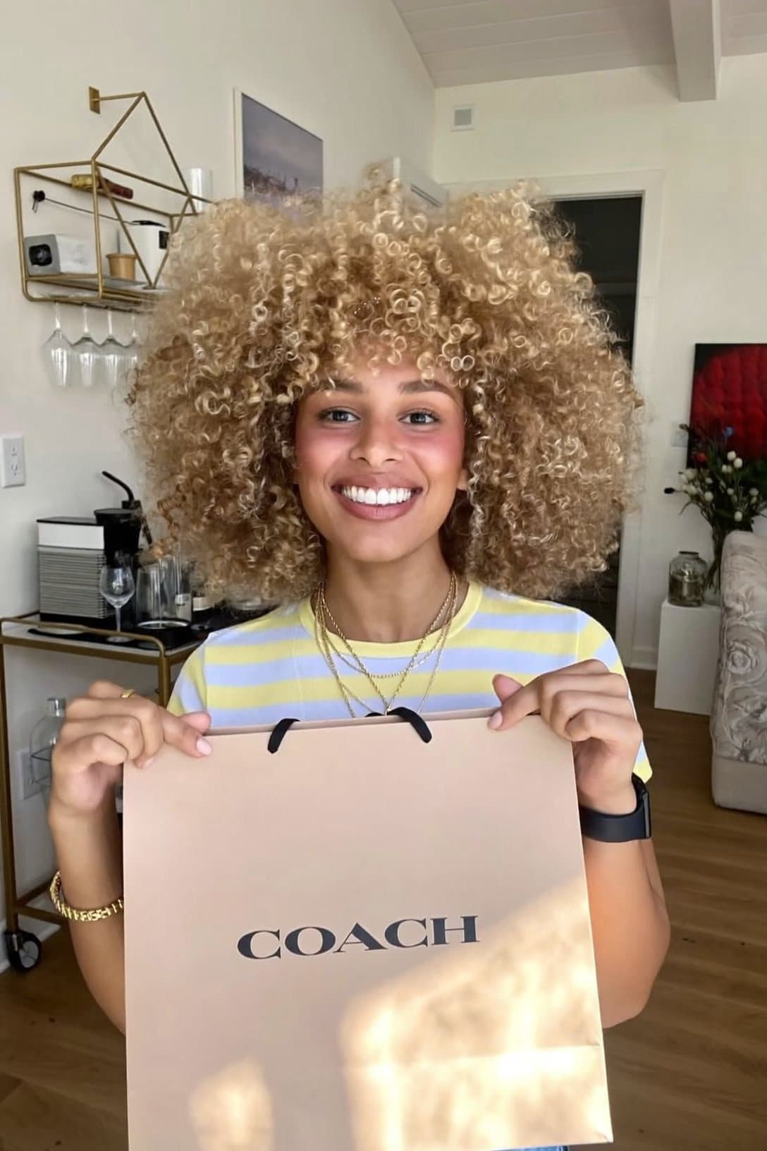 AI presenter smiling to camera holding a Coach shopping bag